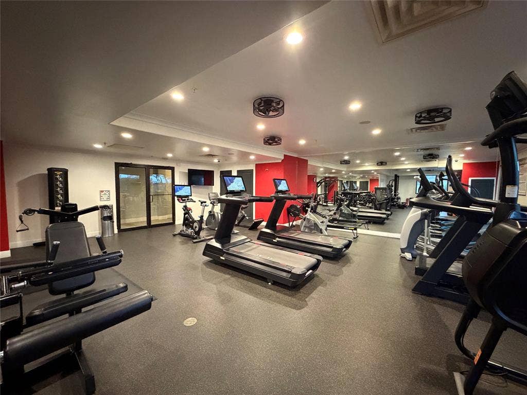 330 Las Colinas Boulevard E, #1006, Irving, TX 75039 Fitness center featuring a rubberized floor, mirrored wall, recessed lighting, and modern exercise equipment