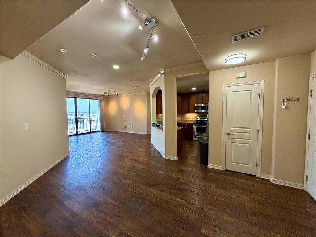 330 Las Colinas Boulevard E, #1006, Irving, TX 75039 Expansive open-concept living area featuring wood-finish flooring, crown molding, and track lighting