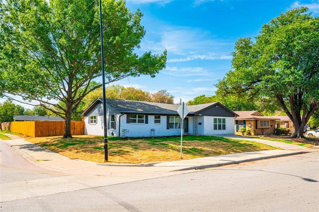 1312 E Mitchell Street, Arlington, TX 76010 Single-story residence with a white exterior finish and dark trim, featuring a corner lot location