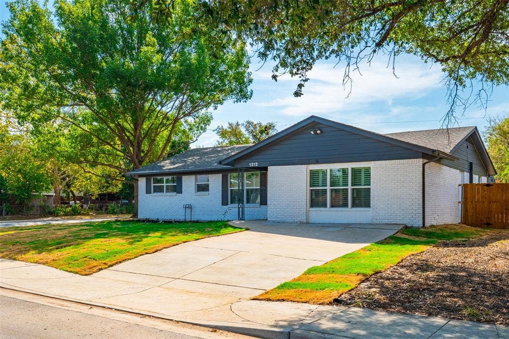1312 E Mitchell Street, Arlington, TX 76010 White painted brick exterior with dark gray siding accents