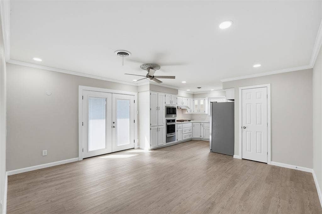 1312 E Mitchell Street, Arlington, TX 76010 Open-concept living area featuring wood-finish flooring, recessed lighting, a ceiling fan, and white French doors