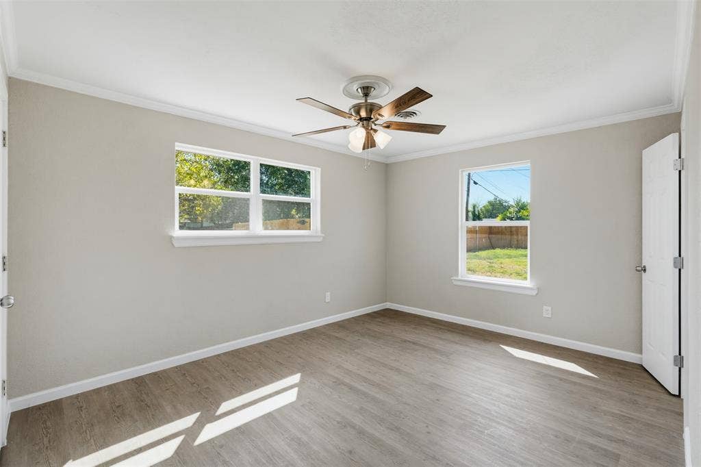 1312 E Mitchell Street, Arlington, TX 76010 Wood-finish flooring with crown molding and a ceiling fan