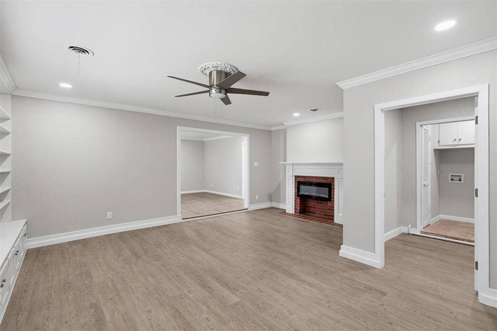 1312 E Mitchell Street, Arlington, TX 76010 Spacious interior featuring wood-finish flooring, a brick fireplace with mantel, ceiling fan, recessed lighting, and built-in shelving