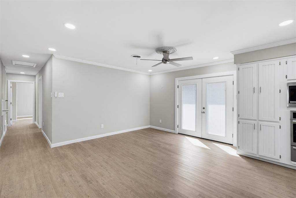 1312 E Mitchell Street, Arlington, TX 76010 Recessed ceiling lighting, wood-finish flooring, ceiling fan, white paneled cabinetry, and double French doors