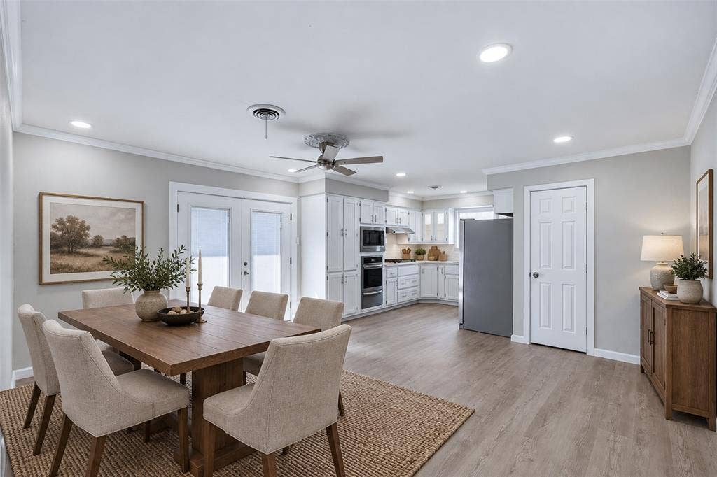 1312 E Mitchell Street, Arlington, TX 76010 Open-concept living space with wood-finish flooring, white cabinetry, integrated stainless steel appliances, and double French doors