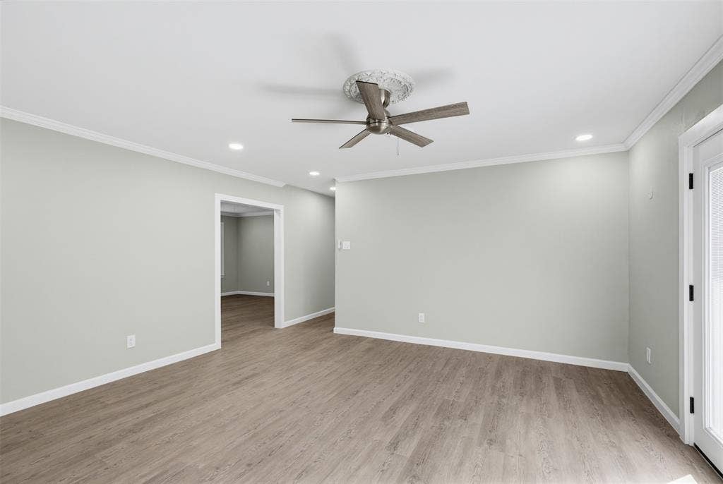 1312 E Mitchell Street, Arlington, TX 76010 Wood-finish flooring, recessed lighting, crown molding, ceiling fan, and white trim throughout