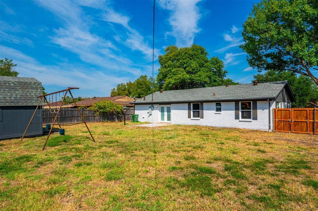 1312 E Mitchell Street, Arlington, TX 76010 Spacious backyard featuring a storage shed, a privacy fence, and a concrete patio