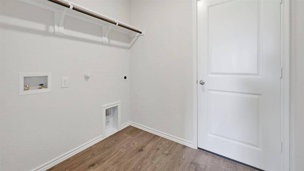 1916 Freeman Street, Tyler, TX 75704 Dedicated utility space featuring wood-finish flooring, white baseboards, and light-toned walls