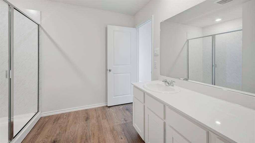 1916 Freeman Street, Tyler, TX 75704 Bathroom featuring a white vanity with an integrated sink, polished chrome faucet, and a large wall-mounted mirror