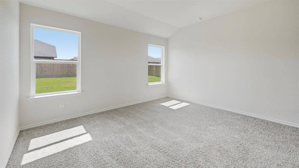 1916 Freeman Street, Tyler, TX 75704 Spacious room featuring vaulted ceilings, light gray carpeting, two windows, and white baseboards