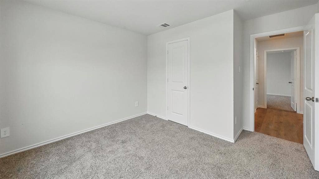 1928 Freeman Street, Tyler, TX 75704 Carpeted room with white walls, white trim, and a white interior door