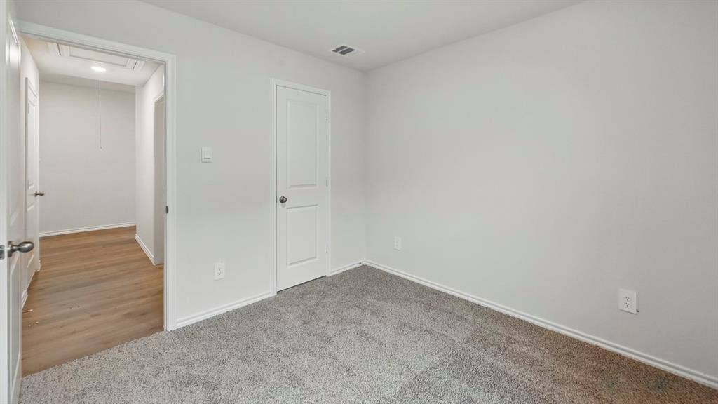 1928 Freeman Street, Tyler, TX 75704 Room featuring light gray carpeting, white walls, white baseboards, and a white interior door