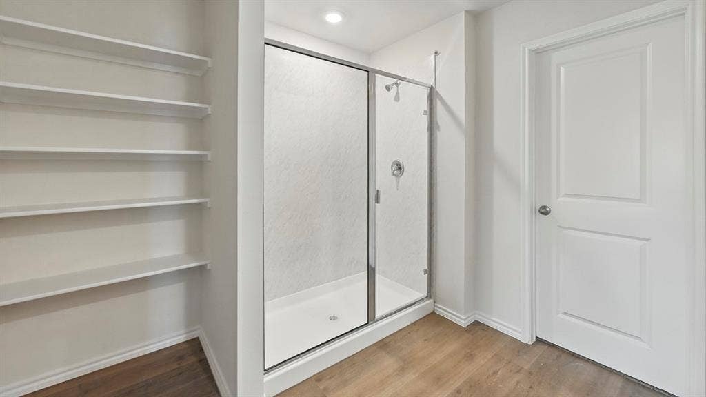 1928 Freeman Street, Tyler, TX 75704 Shower enclosure featuring a clear glass door, chrome hardware, and a white shower pan