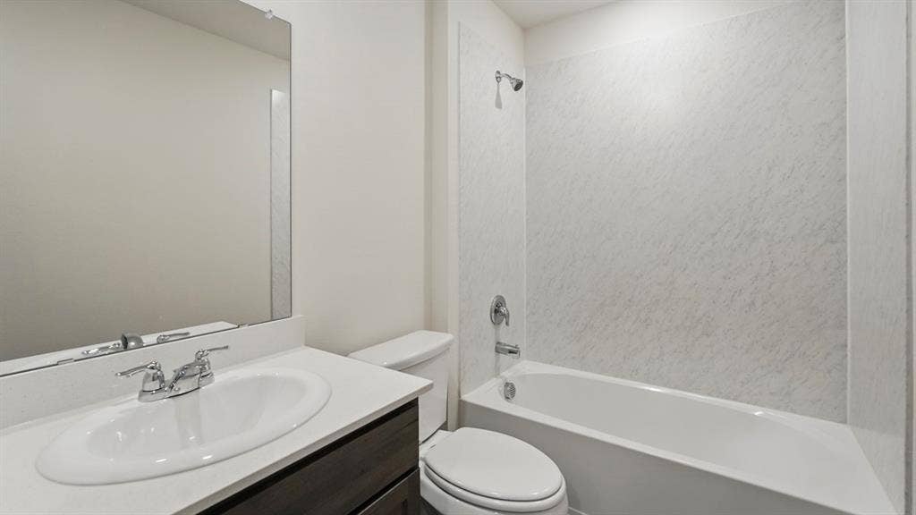 1924 Freeman Street, Tyler, TX 75704 Bathroom featuring a single vanity with an integrated sink, polished chrome faucet, and dark wood-finish cabinetry