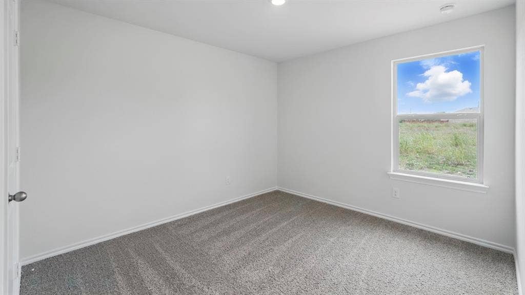 1924 Freeman Street, Tyler, TX 75704 Spacious room featuring neutral carpeting, white walls, a single window with white trim, and a recessed ceiling light