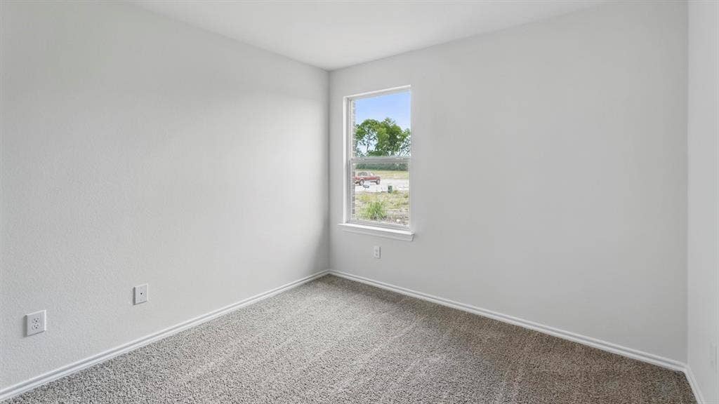 1924 Freeman Street, Tyler, TX 75704 Neutral-toned room featuring a single window with white trim, light gray textured walls, and gray carpet flooring