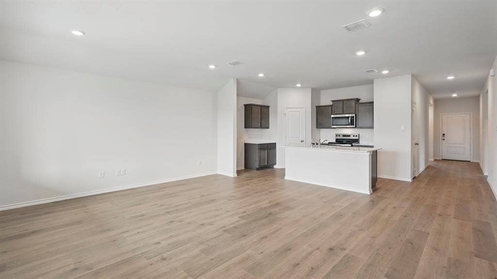 1924 Freeman Street, Tyler, TX 75704 Open-concept living area with wood-finish flooring, recessed lighting, and a white color palette