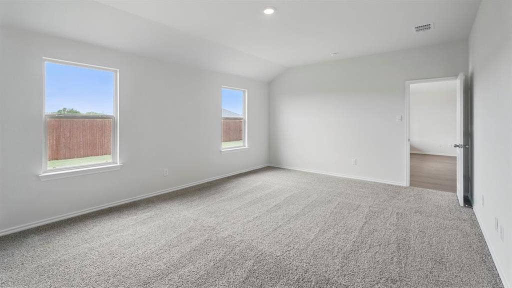 1924 Freeman Street, Tyler, TX 75704 Spacious room featuring neutral carpeting, white walls, two windows, recessed lighting, and a vaulted ceiling