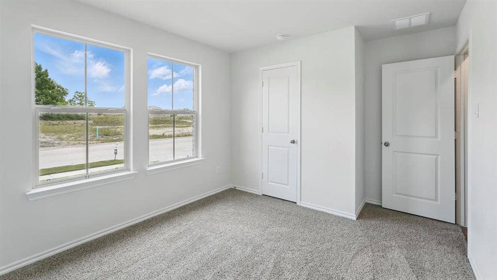 1924 Freeman Street, Tyler, TX 75704 Carpeted room with white walls, two double-hung windows, and two white panel doors