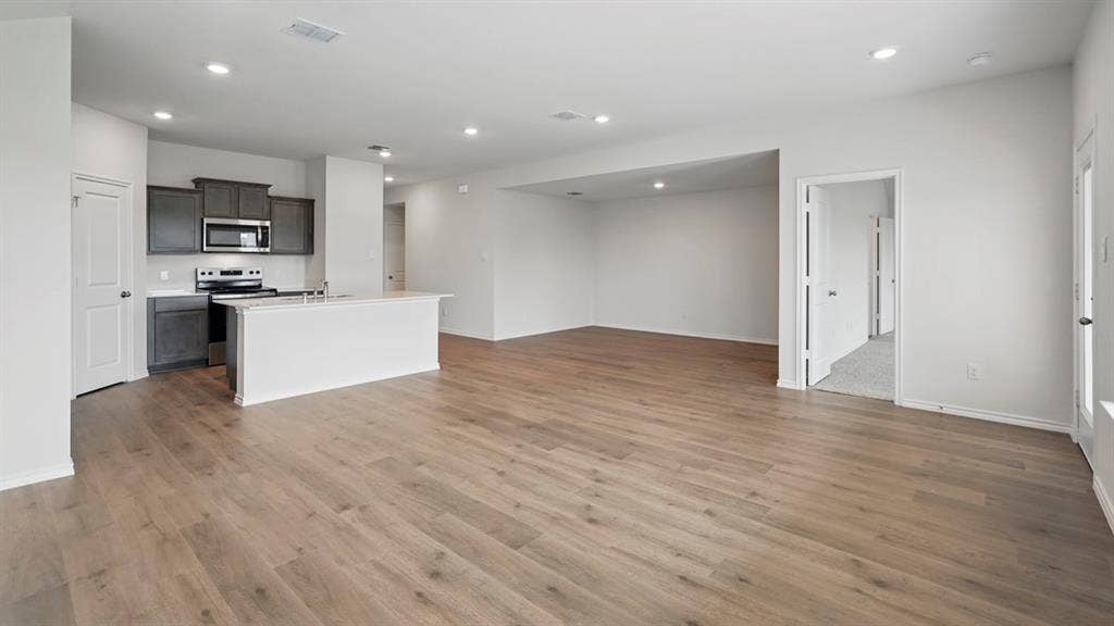 1924 Freeman Street, Tyler, TX 75704 Open concept living area featuring wood-finish flooring, recessed lighting, and a kitchen island with a sink