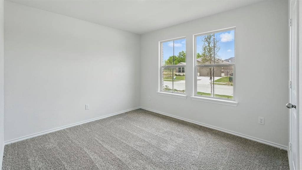 1924 Freeman Street, Tyler, TX 75704 Spacious room featuring two large windows, light gray walls, gray patterned carpeting, and white trim