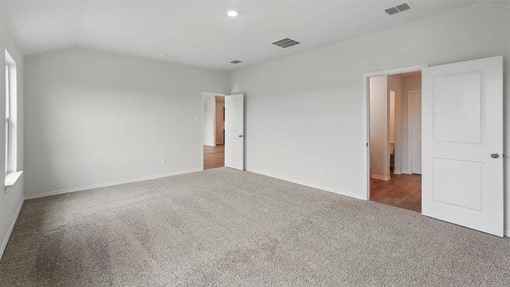 1924 Freeman Street, Tyler, TX 75704 Spacious room featuring vaulted ceilings, light gray carpeting, a window, and two paneled doors with hardware