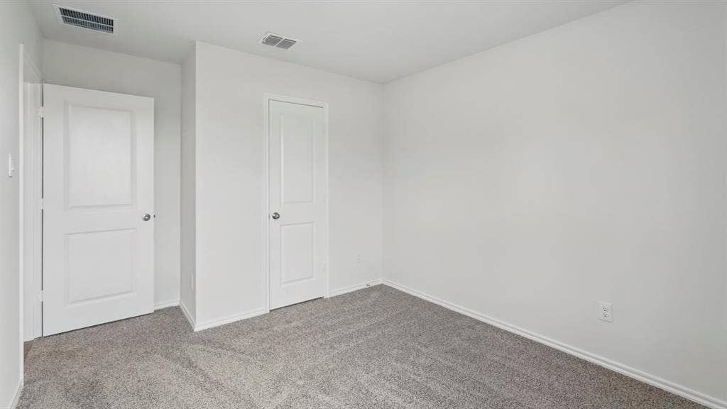 1924 Freeman Street, Tyler, TX 75704 Neutral white wall finishes, two white two-panel interior doors, gray carpet flooring, and white baseboards