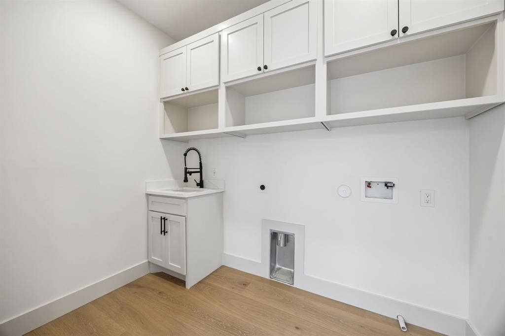 3027 Brooklyndell Avenue, Dallas, TX 75211 Laundry room with open and closed storage and a sink.