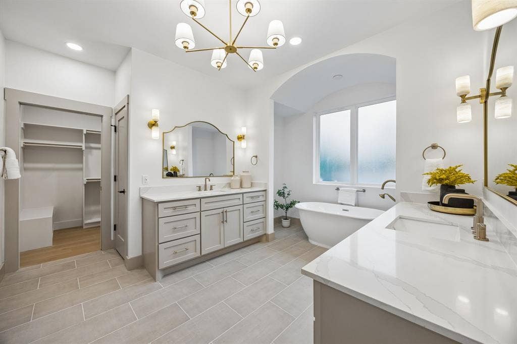 3027 Brooklyndell Avenue, Dallas, TX 75211 Spacious ensuite bathroom featuring a freestanding tub, dual vanities and a walk-in closet with built-in shelving