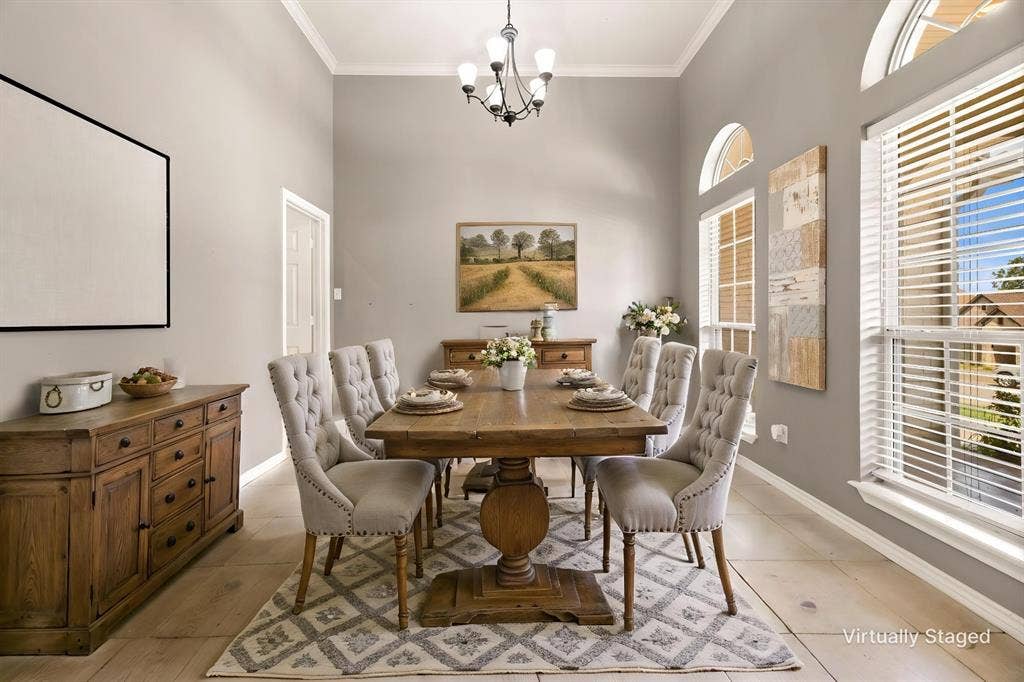 618 Huntwick Lane, Tyler, TX 75703 Vaulted ceiling with crown molding, wood-finish flooring, multiple arched windows, and a classic chandelier