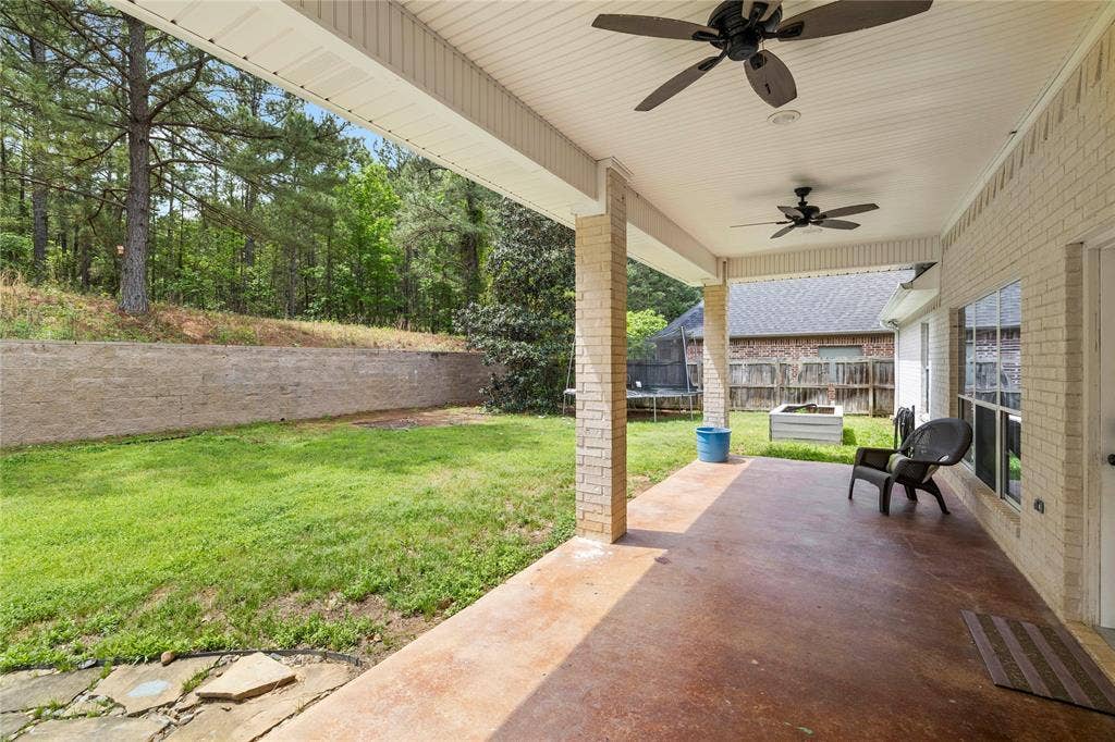 618 Huntwick Lane, Tyler, TX 75703 Expansive covered patio with a stained concrete floor, ceiling fans, and brick columns