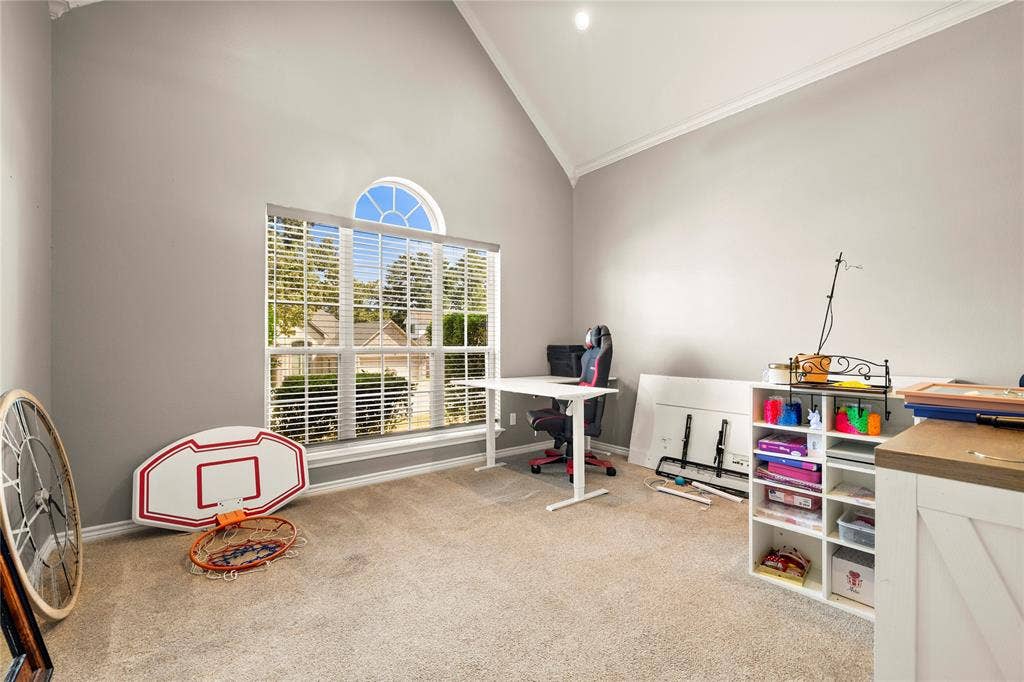 618 Huntwick Lane, Tyler, TX 75703 Vaulted ceiling with crown molding, window with arch top, and neutral carpeting