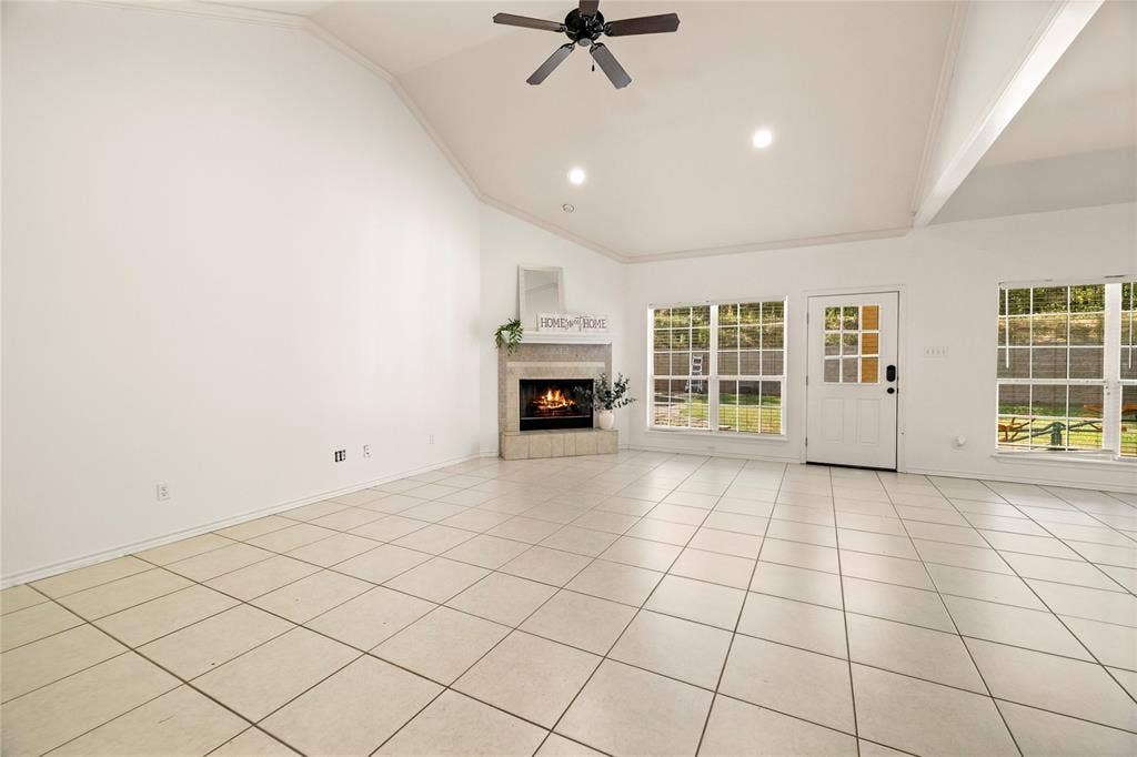 618 Huntwick Lane, Tyler, TX 75703 Vaulted ceiling with a ceiling fan and recessed lighting, corner fireplace, ceramic tile flooring, and multiple windows