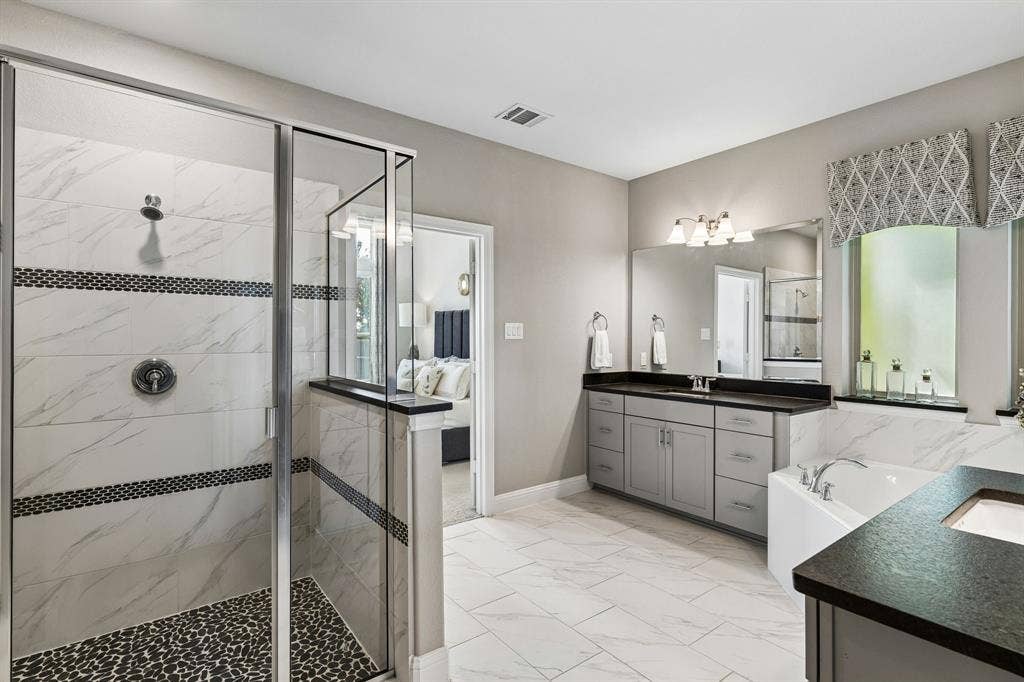 3707 Roth Drive, McKinney, TX 75071 Beautifully appointed primary bath continues the home’s sophisticated aesthetic with marble-look surfaces, generous vanity storage, decorative window treatments, and abundant natural light.