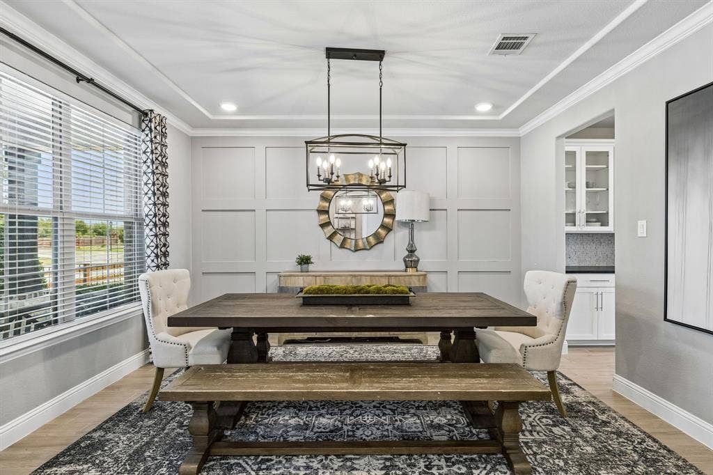 3707 Roth Drive, McKinney, TX 75071 Refined formal dining room offers timeless architectural paneling, an elegant chandelier, designer-inspired finishes, and abundant natural light through expansive windows.