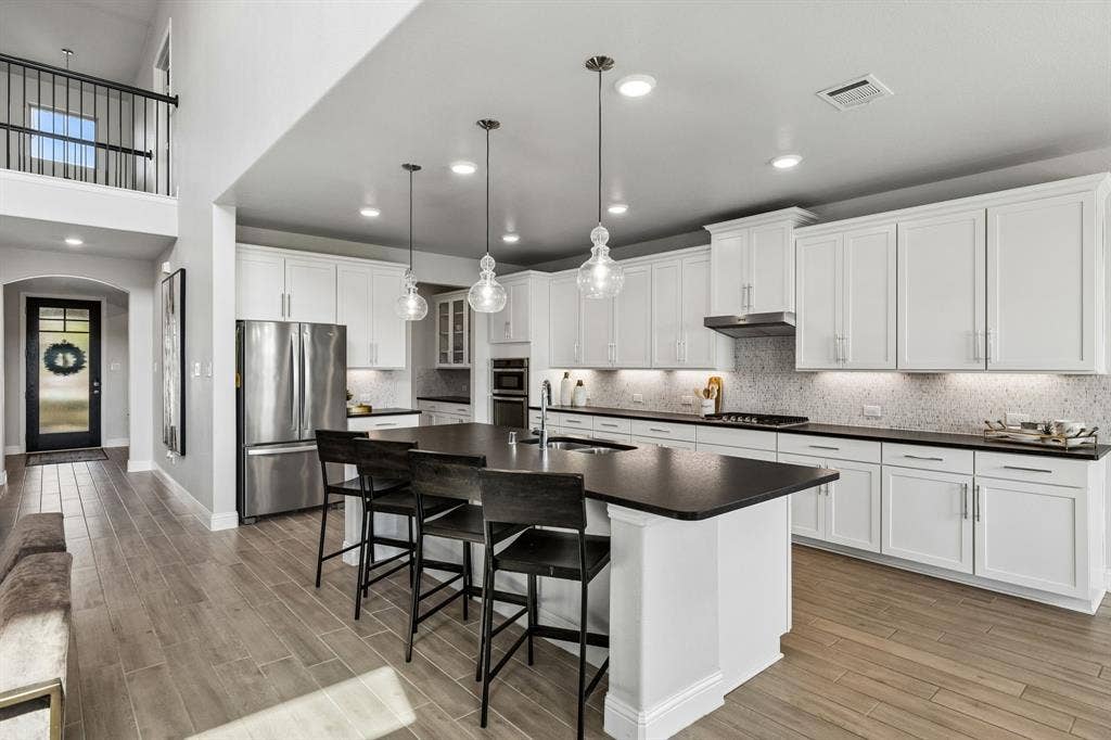 3707 Roth Drive, McKinney, TX 75071 This kitchen has exceptional functionality and connection to the living spaces, with extensive cabinetry, oversized island, pendant lighting, and abundant natural illumination.