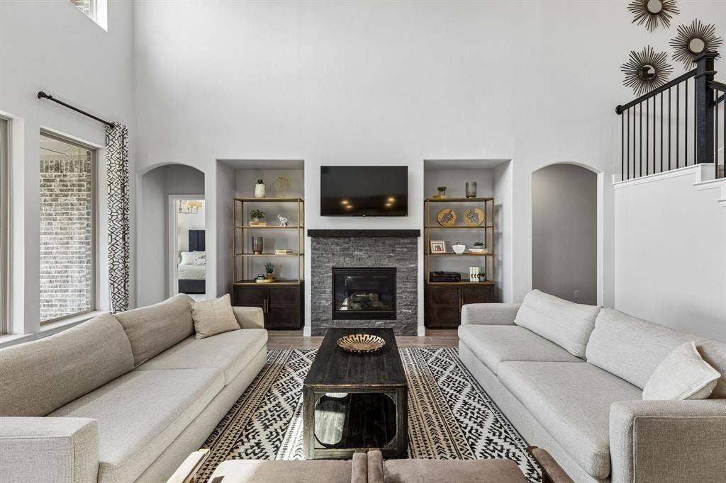 3707 Roth Drive, McKinney, TX 75071 Sophisticated living room centers around a handsome fireplace with custom-style built-ins, complemented by a generous seating area, designer finishes, and dramatic ceiling height.