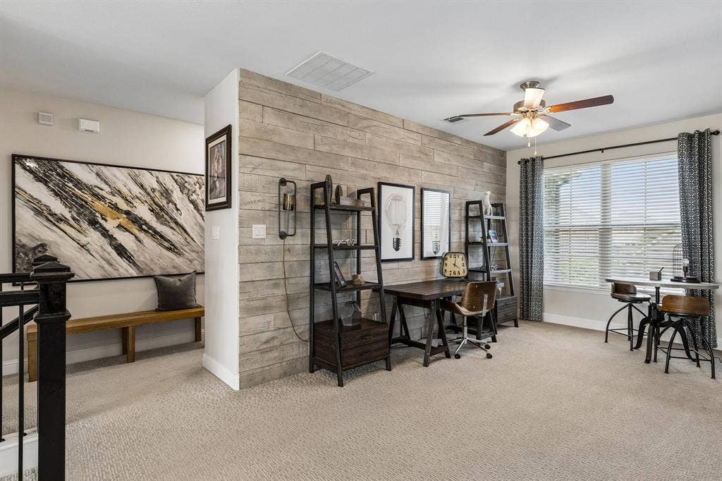 3707 Roth Drive, McKinney, TX 75071 Versatile game room and flex space combines refined functionality with distinctive character, featuring a dramatic reclaimed-wood accent wall and abundant natural light. The adjoining sitting area adds flexibility for work, study, or relaxation.
