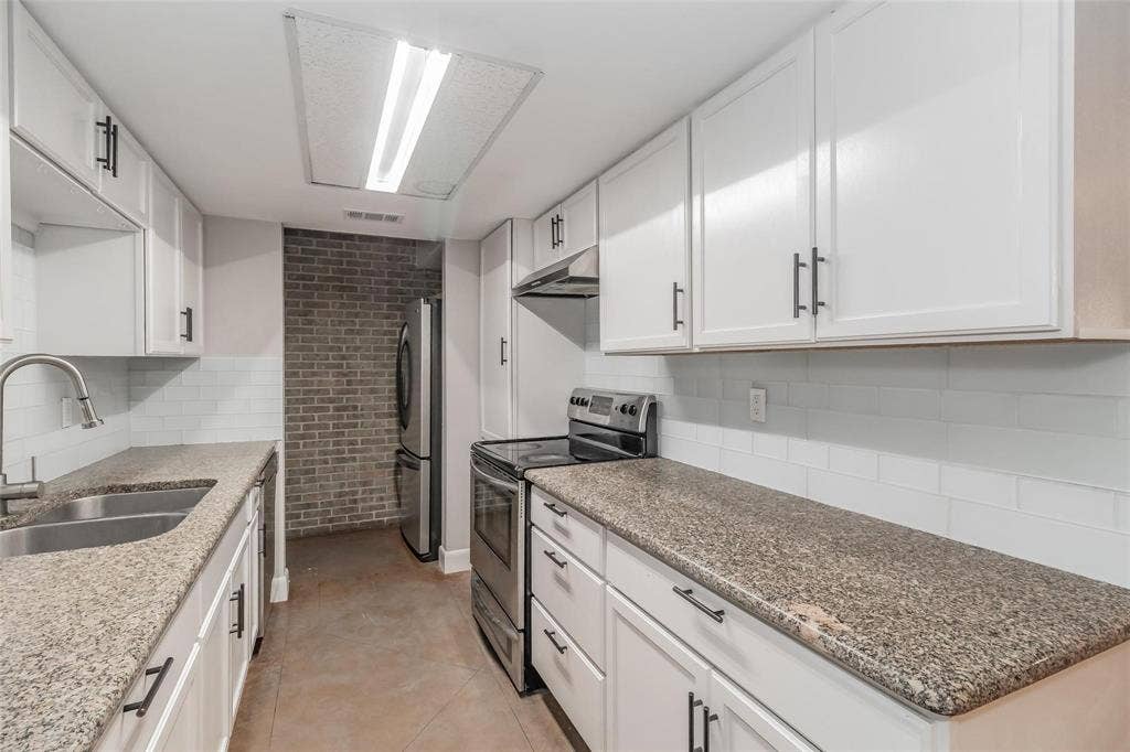 4930 Thunder Road, Dallas, TX 75244 Kitchen featuring white cabinetry, granite countertops, a stainless steel double sink, and a subway tile backsplash