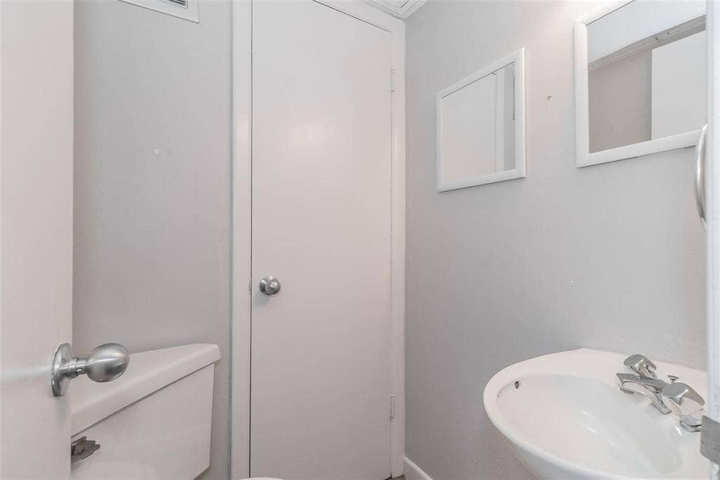 4930 Thunder Road, Dallas, TX 75244 Pedestal sink with chrome faucet, wall-mounted mirror, and white interior door