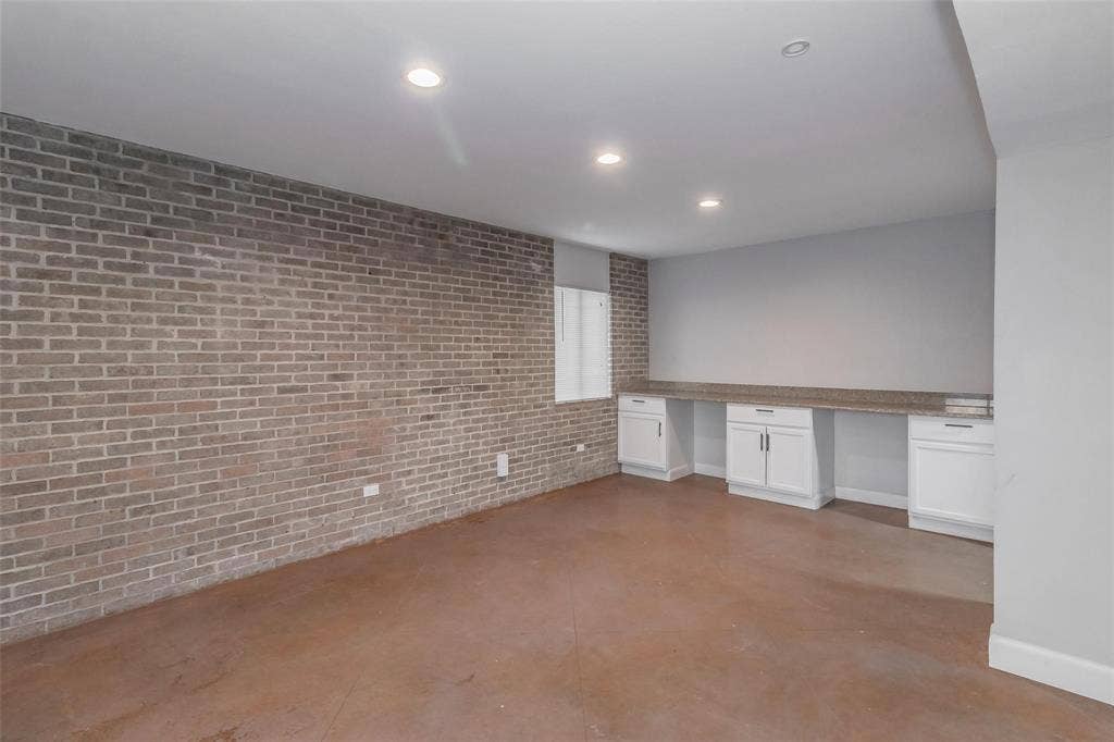 4930 Thunder Road, Dallas, TX 75244 Exposed brick wall with built-in cabinetry, counter space, and recessed lighting