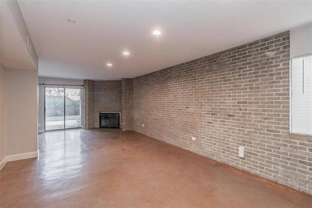 4930 Thunder Road, Dallas, TX 75244 Exposed brick wall, recessed lighting, fireplace, sliding glass door, and hard-surface flooring