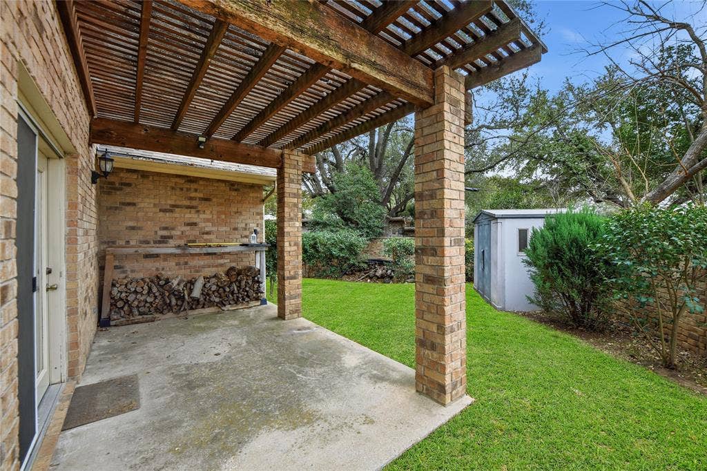 4424 Westridge Avenue, Fort Worth, TX 76116 Concrete patio with a wood pergola, brick columns, and a grassy yard