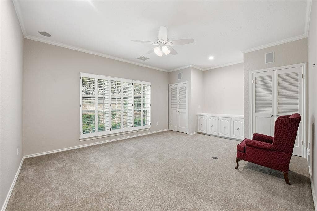 4424 Westridge Avenue, Fort Worth, TX 76116 Window with plantation shutters, built-in cabinetry, two sets of louvered bifold doors, and a ceiling fan with integrated lighting