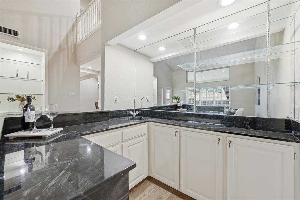 4424 Westridge Avenue, Fort Worth, TX 76116 Built-in wet bar with dark countertops, white cabinetry, and a mirrored backsplash
