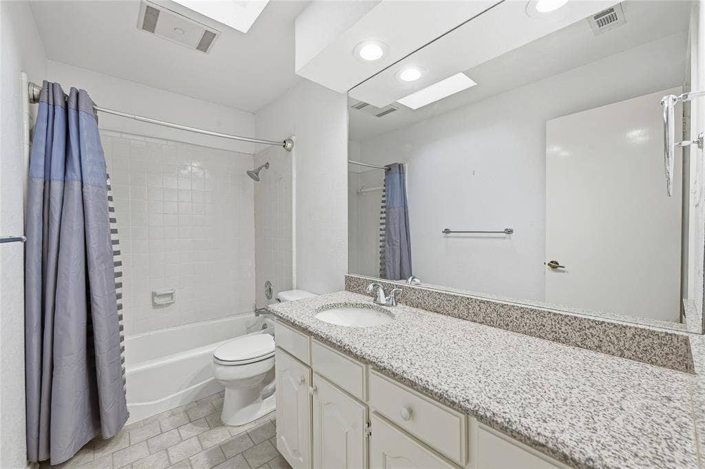 4424 Westridge Avenue, Fort Worth, TX 76116 Bathroom featuring a vanity with a light speckled countertop, white cabinetry, integrated sink, and an expansive wall-mounted mirror
