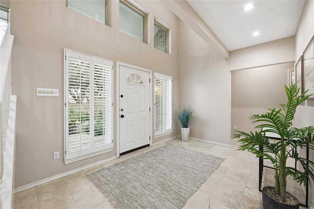 4424 Westridge Avenue, Fort Worth, TX 76116 Vaulted ceiling entryway with transom windows, a paneled front door, sidelight windows, and light-toned tile flooring
