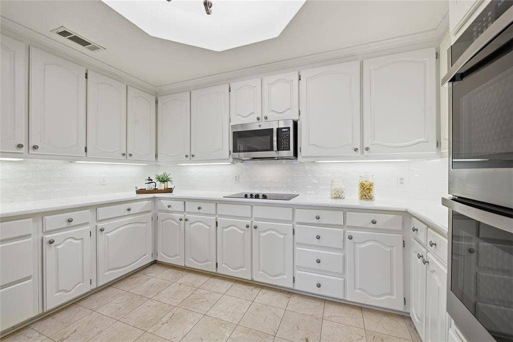 4424 Westridge Avenue, Fort Worth, TX 76116 White cabinetry with brushed nickel hardware, white countertops, white tile backsplash, stainless steel appliances, and tiled flooring