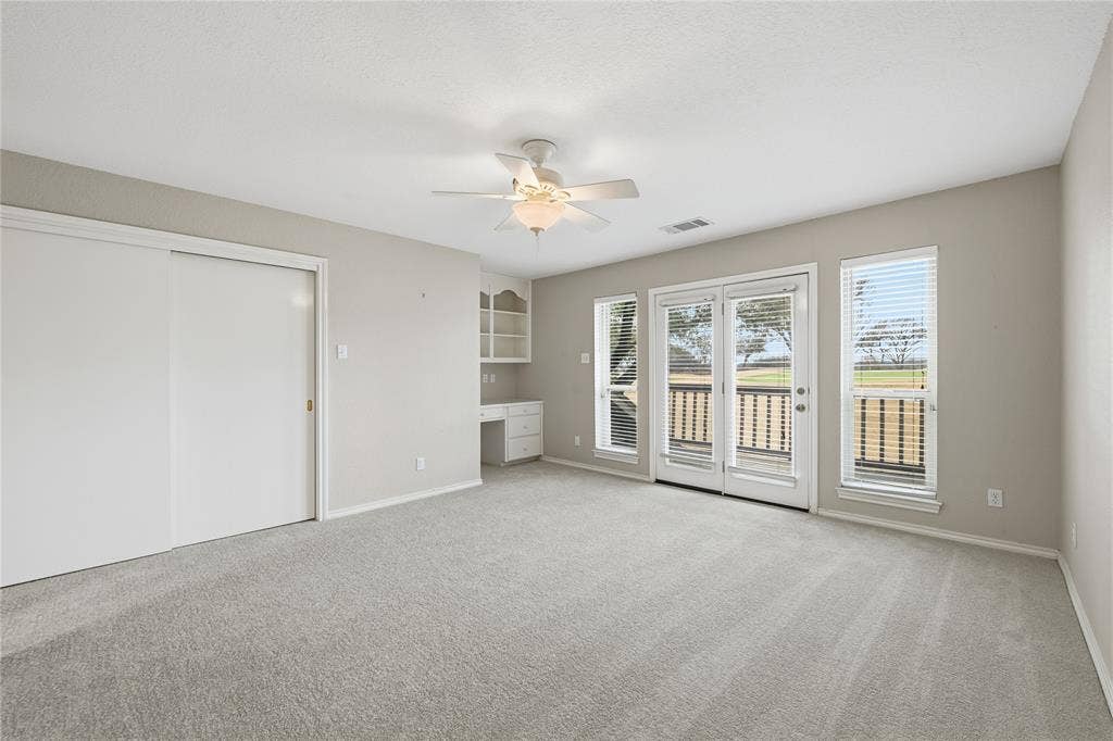 4424 Westridge Avenue, Fort Worth, TX 76116 Spacious room with light-toned carpeting, built-in shelving, a ceiling fan, and French doors opening to an exterior balcony