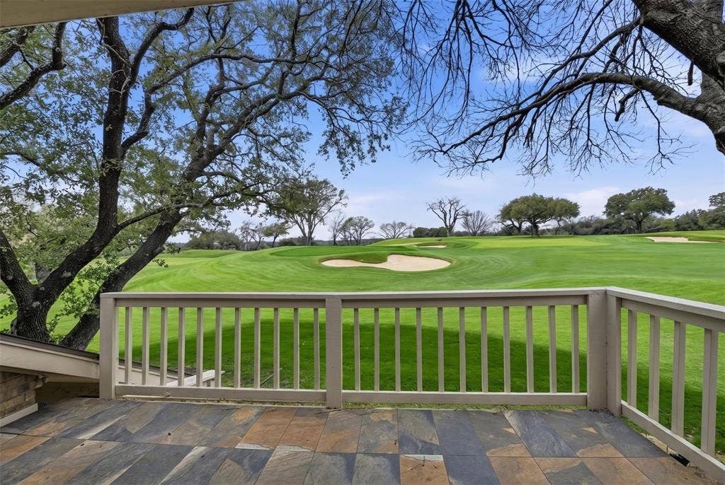 4424 Westridge Avenue, Fort Worth, TX 76116 Multicolor stone-tiled deck with a light-toned wood railing, featuring mature trees and golf course landscaping